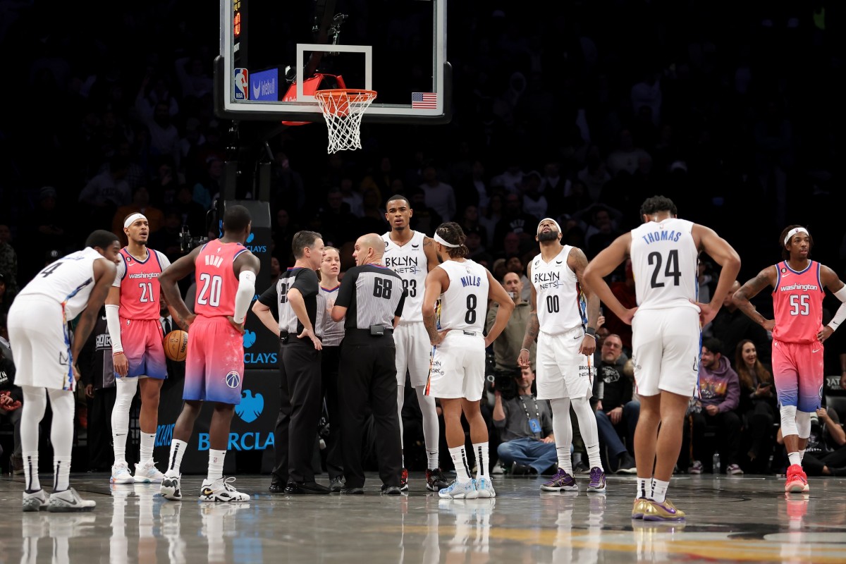 Referees huddle to discuss a foul by Washington Wizards forward Deni Avdija (9) and a goaltending by Wizards center Daniel Gafford (21) against Brooklyn Nets guard Cam Thomas (24) during the fourth quarter at Barclays Center.